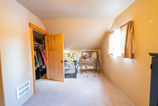 interior space with carpet, a closet, a walk in closet, and vaulted ceiling