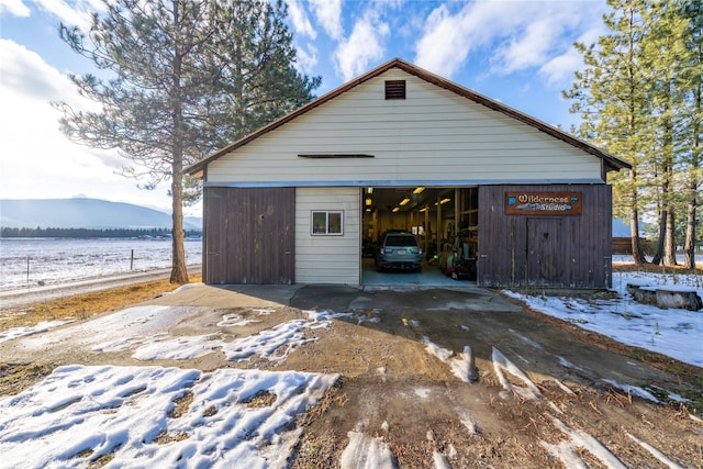 snow covered garage featuring a mountain view