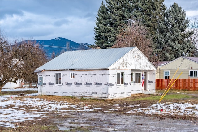 snow covered rear of property with a mountain view