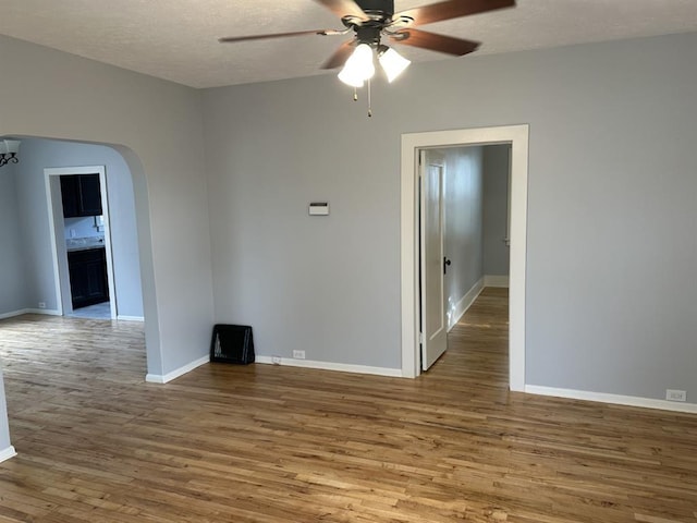 empty room featuring hardwood / wood-style flooring, ceiling fan, and a textured ceiling