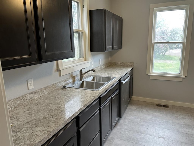 kitchen featuring dark brown cabinets, stainless steel dishwasher, and sink