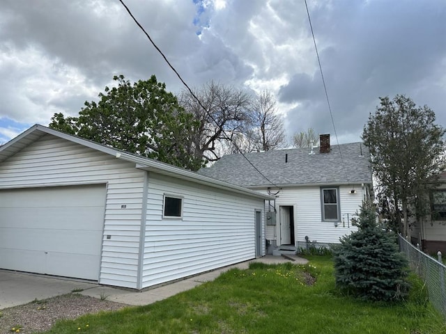 back of house with a yard and a garage