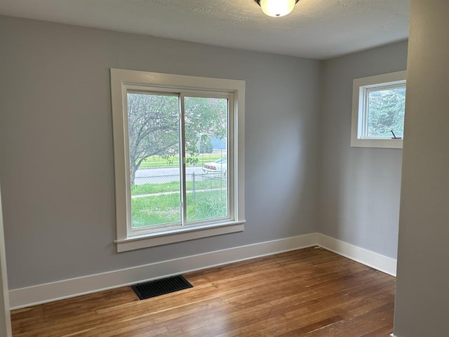 unfurnished room with hardwood / wood-style flooring