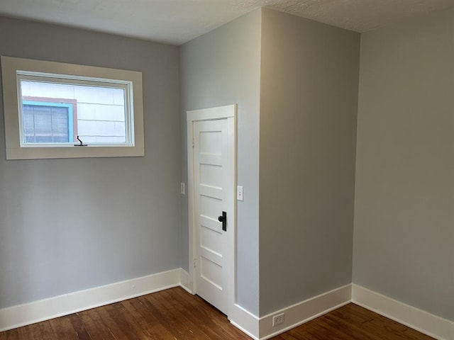 empty room with dark hardwood / wood-style flooring