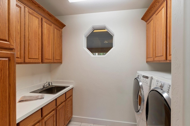 clothes washing area featuring cabinets, light tile patterned floors, washer and dryer, and sink