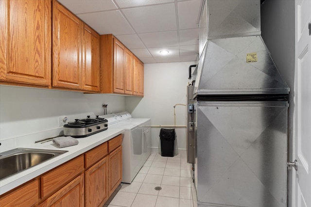 laundry room featuring light tile patterned floors, washer / clothes dryer, heating unit, and sink