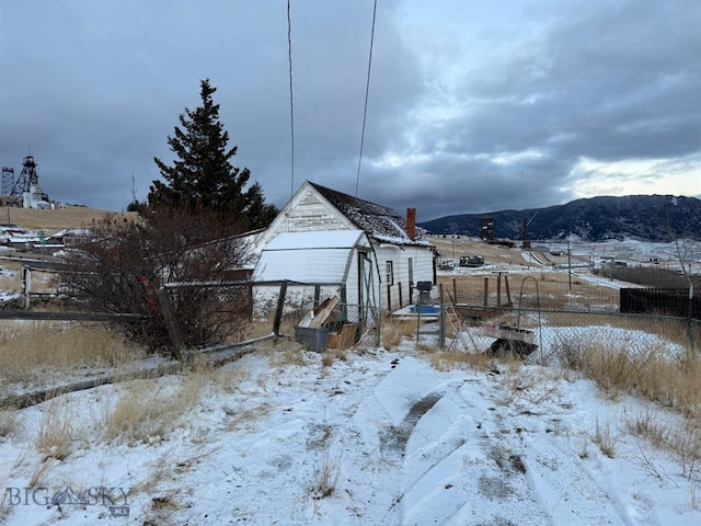 yard layered in snow featuring a mountain view