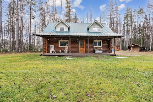 cabin featuring a porch, a storage shed, and a front yard