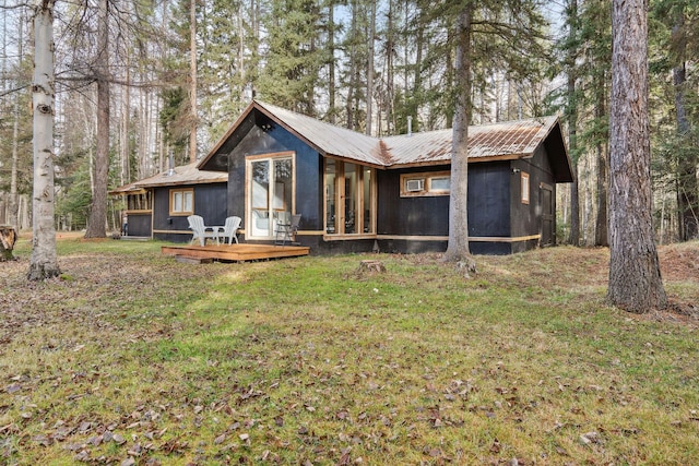 back of house featuring a lawn and a wooden deck