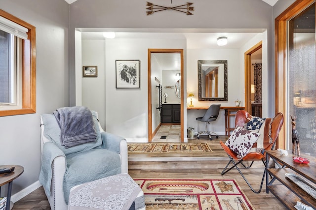 living area with built in desk, hardwood / wood-style flooring, and lofted ceiling