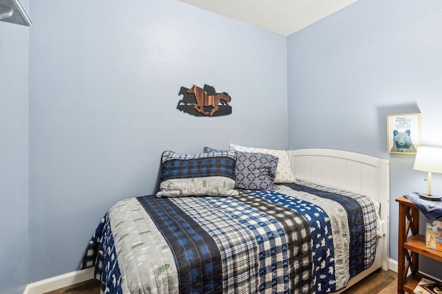 bedroom with dark hardwood / wood-style flooring