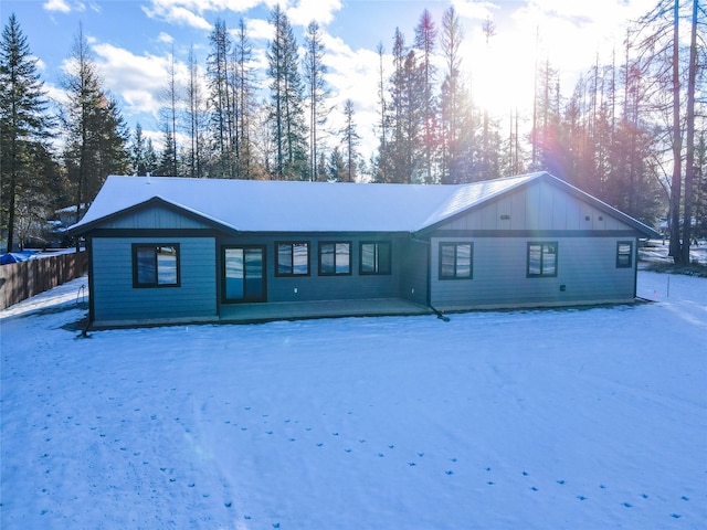 view of snow covered back of property