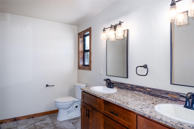 bathroom with vanity, toilet, and backsplash