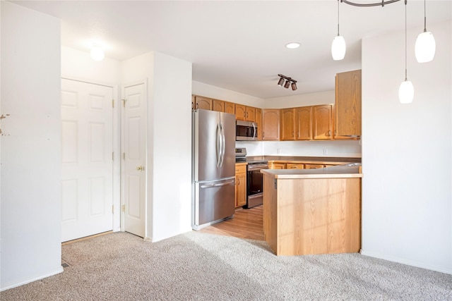 kitchen with kitchen peninsula, light carpet, pendant lighting, and appliances with stainless steel finishes