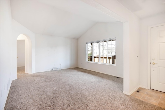 unfurnished room featuring light colored carpet and lofted ceiling