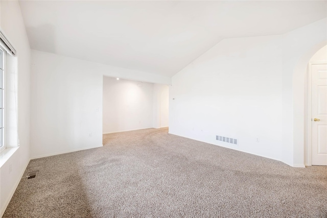 unfurnished room featuring carpet flooring and lofted ceiling