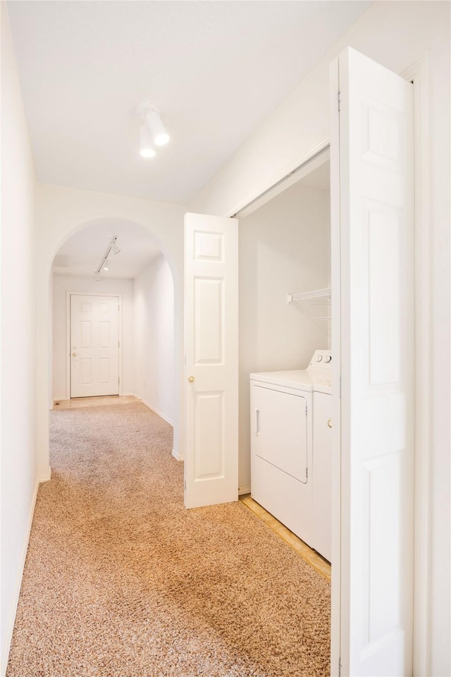 hall featuring carpet flooring and independent washer and dryer