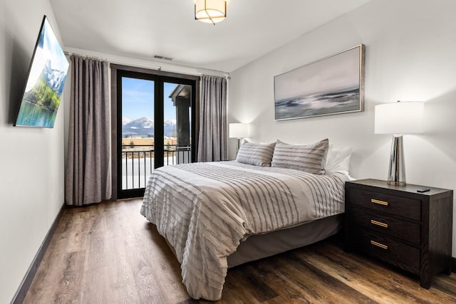 bedroom with access to exterior and hardwood / wood-style floors