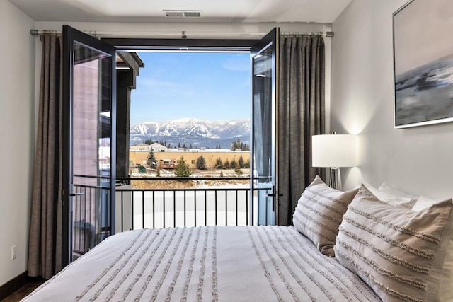 bedroom with a mountain view and access to outside