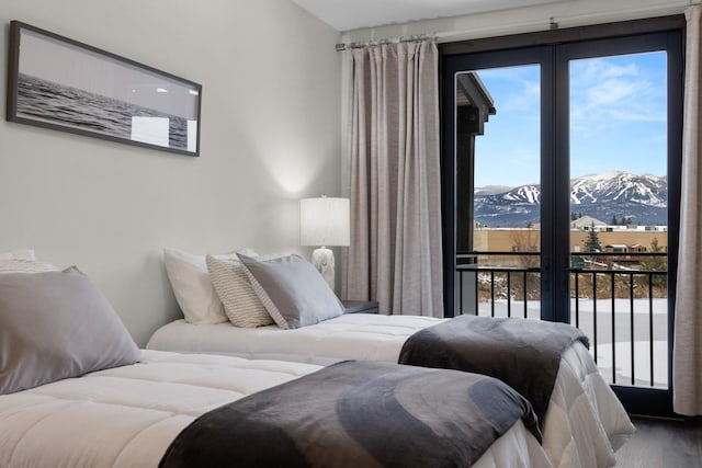 bedroom featuring a mountain view, access to exterior, and hardwood / wood-style flooring