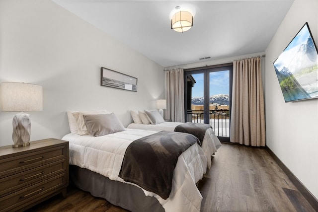 bedroom featuring access to exterior, dark wood-style floors, and baseboards