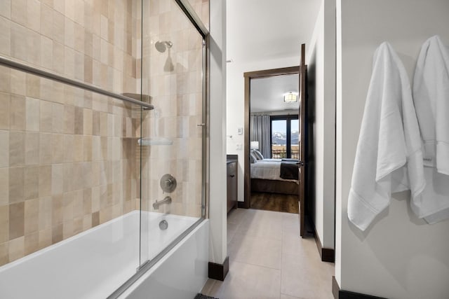 bathroom with tile patterned flooring and bath / shower combo with glass door