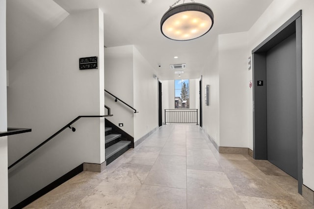 hall featuring elevator and baseboards