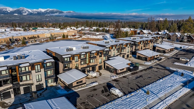 snowy aerial view with a mountain view and a residential view