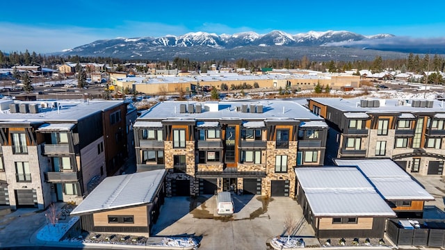 snowy aerial view with a mountain view and a residential view
