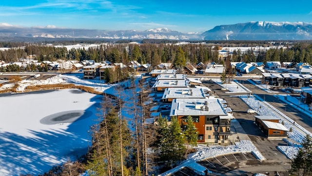 snowy aerial view with a mountain view and a residential view
