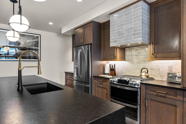 kitchen with stainless steel appliances, a sink, wall chimney exhaust hood, tasteful backsplash, and dark brown cabinets