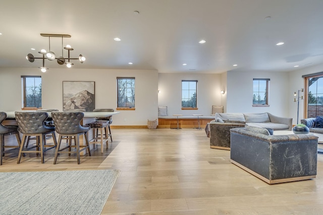 living room featuring light hardwood / wood-style flooring and an inviting chandelier