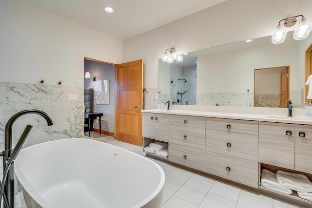 bathroom with tile patterned floors, vanity, tile walls, and independent shower and bath