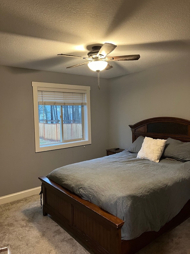 bedroom featuring carpet, ceiling fan, and a textured ceiling