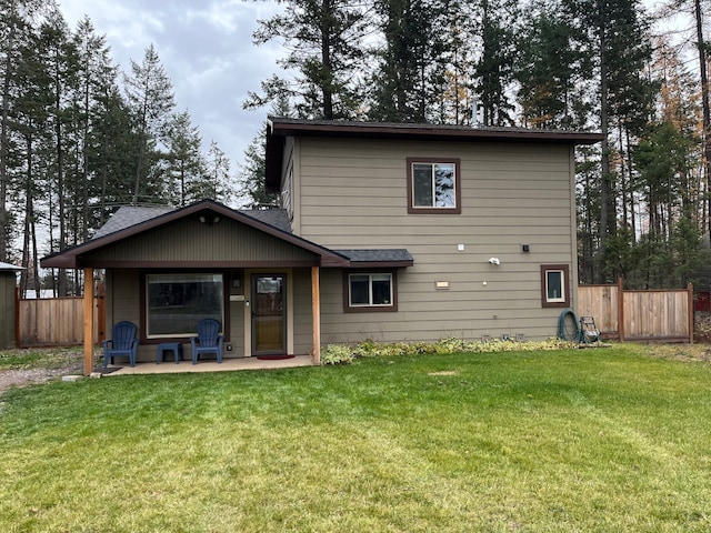 rear view of property with a yard and a patio