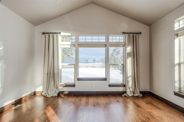 unfurnished room with dark wood-type flooring, high vaulted ceiling, and baseboards