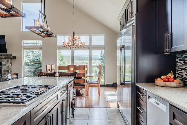 kitchen with stainless steel appliances, light tile patterned flooring, plenty of natural light, and backsplash