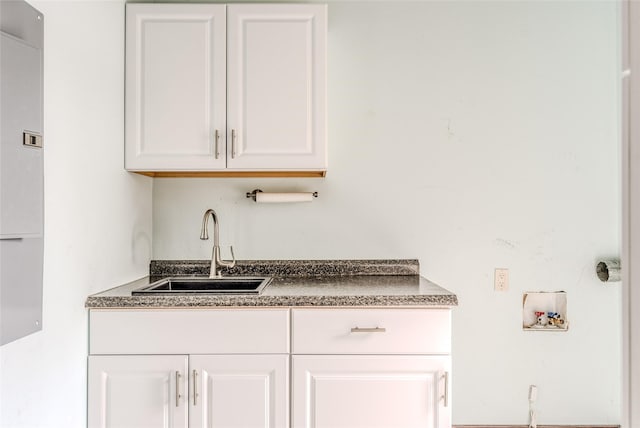 interior space featuring dark countertops, white cabinets, and a sink