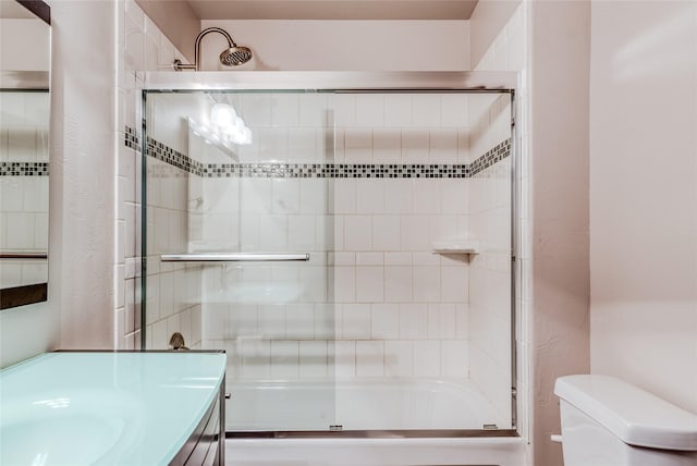 full bathroom featuring enclosed tub / shower combo, vanity, and toilet