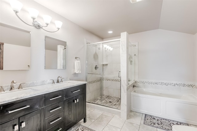 bathroom with a garden tub, double vanity, a stall shower, vaulted ceiling, and a sink