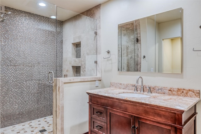 bathroom with a stall shower, recessed lighting, and vanity