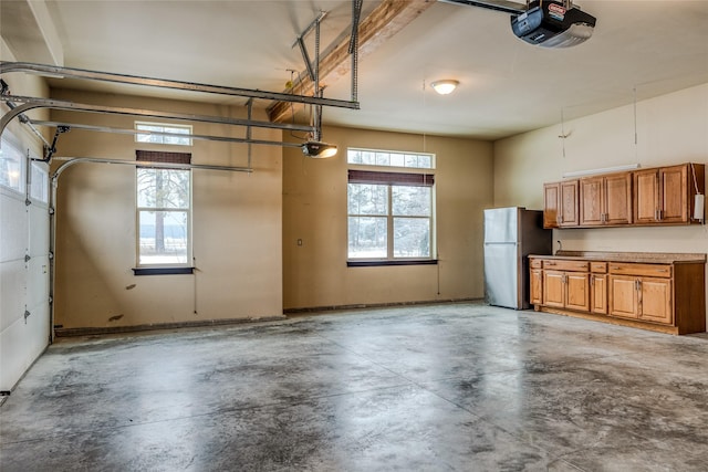 garage featuring freestanding refrigerator and a garage door opener