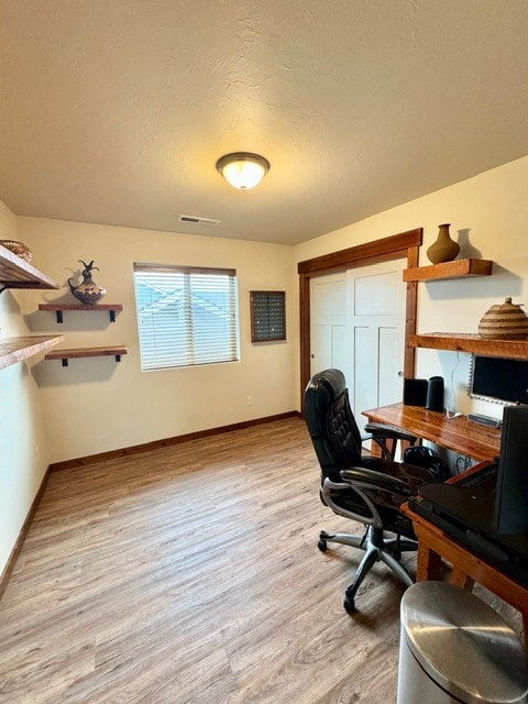 office with a textured ceiling and light hardwood / wood-style flooring