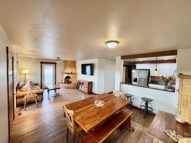 dining room with a large fireplace and hardwood / wood-style floors