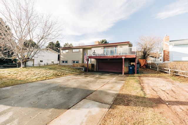 view of front of home featuring a garage, a deck, and a front lawn