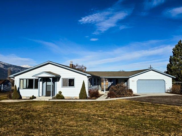 single story home with a garage and a front yard