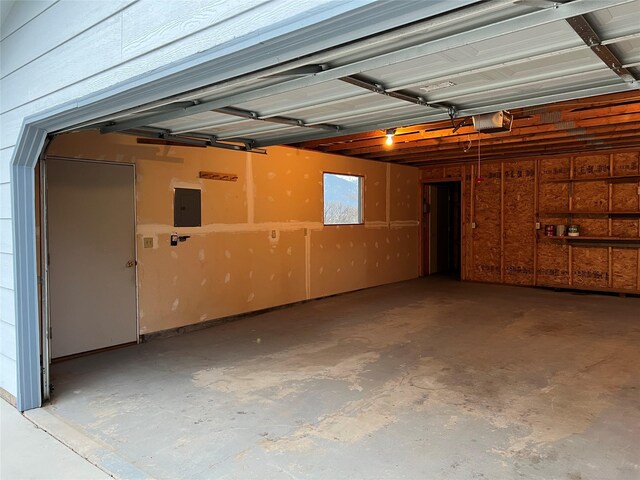 garage with a garage door opener and electric panel