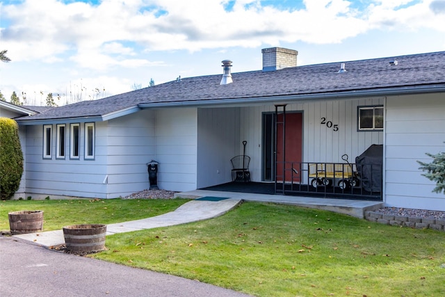 rear view of property featuring a yard