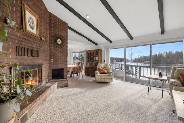 sunroom with a fireplace, a water view, and lofted ceiling with beams