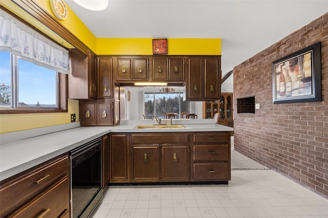 kitchen with a healthy amount of sunlight, sink, brick wall, and black dishwasher